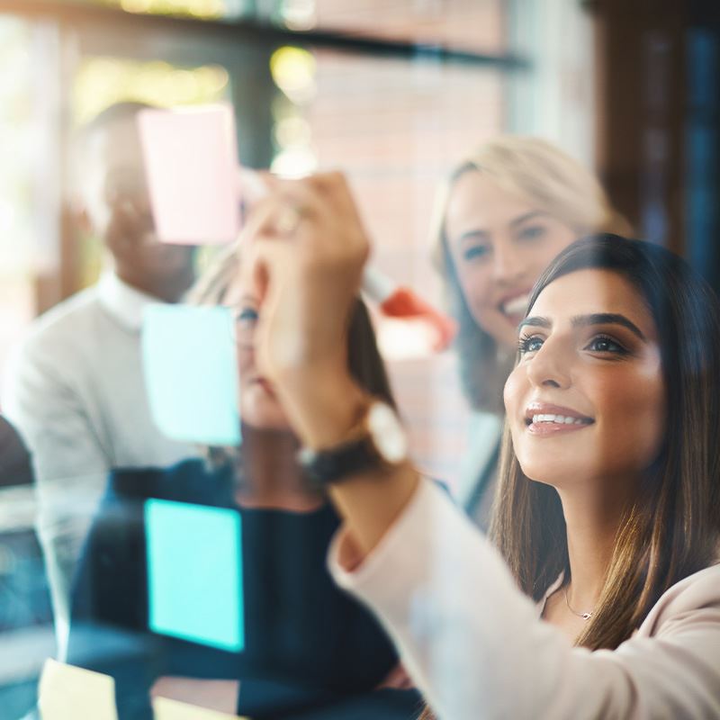Several people gather around a sticky note, analyzing its content with curiosity and interest.